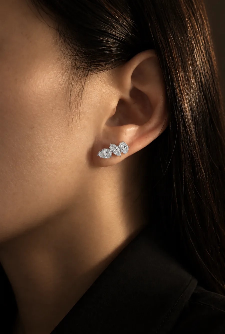 A Trio Earring worn along the lobe, in warm low light