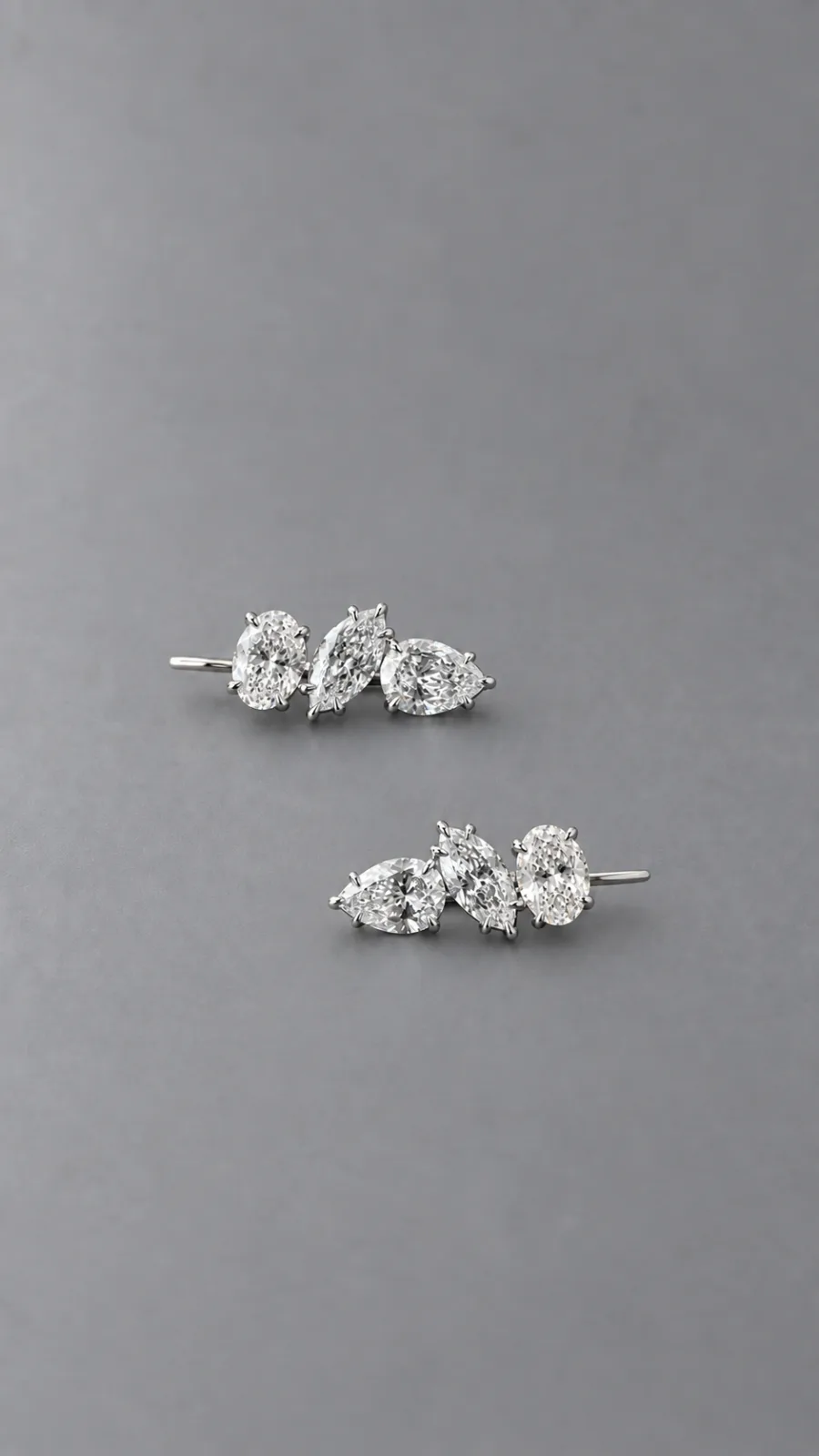 Pair of Trio Earrings — oval, marquise and pear diamonds — on a grey background